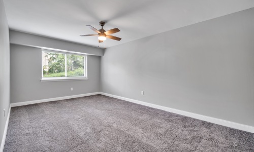 a bedroom with carpet and a fan