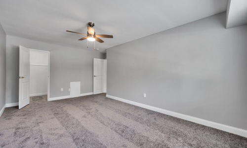 a bedroom with carpet and a fan